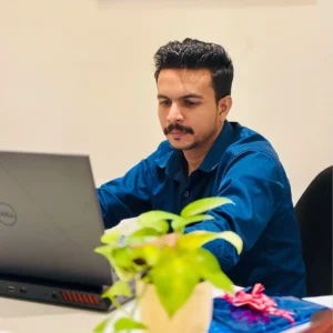 Portrait of Adhil Noushad working on laptop, creative director and best graphic designer in Kerala